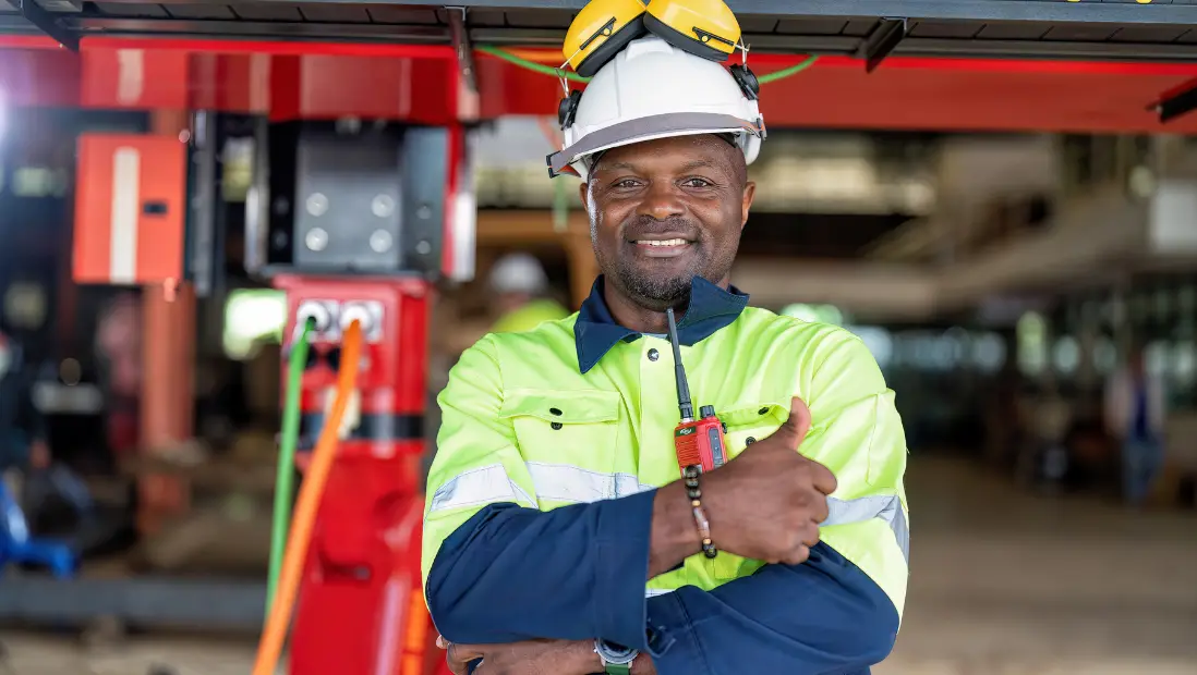 Une ingénieure en tenue haute visibilité et casque de chantier sur un site
